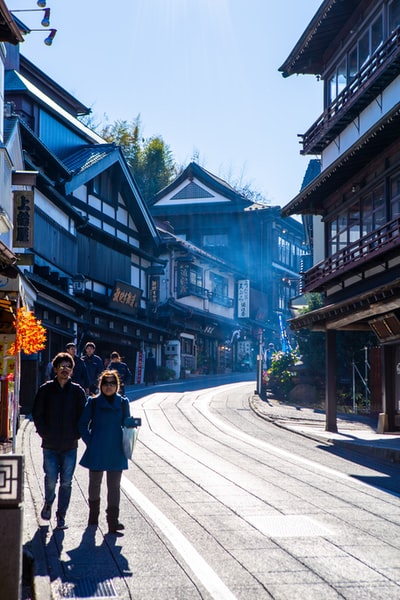 People walking on the narrow street between the houses
